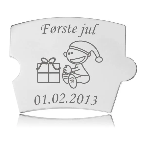 Memozz Spin mindebrik i håndpoleret rustfrit stål, graveret med et nissebarn, en julegave og teksten "Første jul".