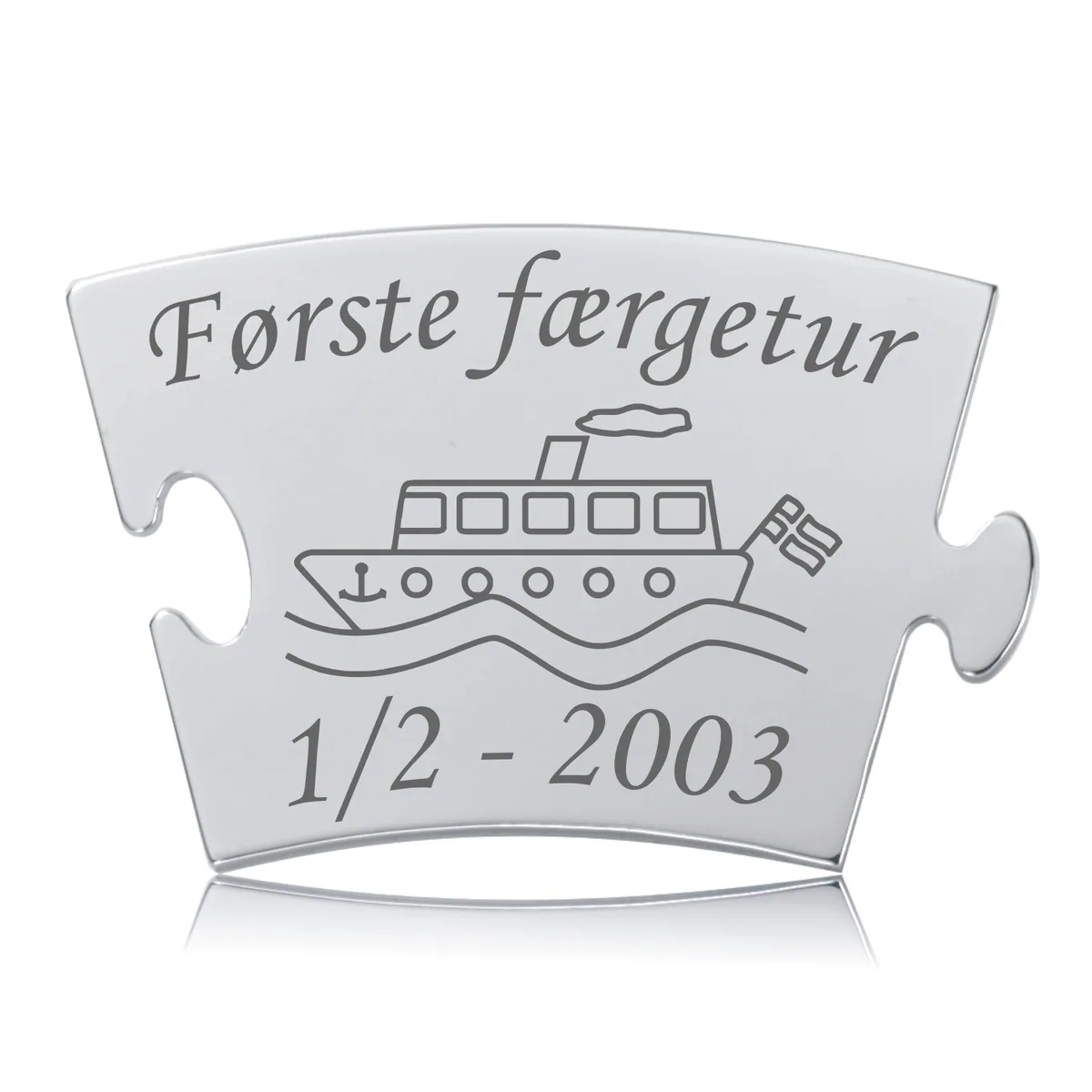 Memozz Classic brik "Første færgetur" i poleret rustfrit stål med detaljeret lasergravering af en færge og teksten "Første færgetur".