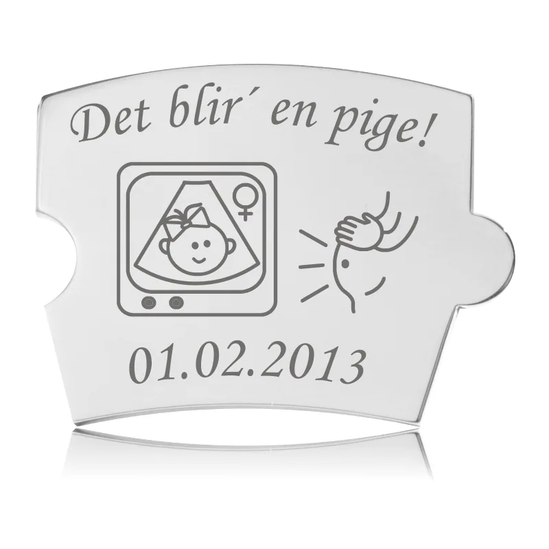 Memozz Spin brik i poleret stål med gravering af 'Det blir' en pige!', ultralydsbillede af pige, og en gravid mave.