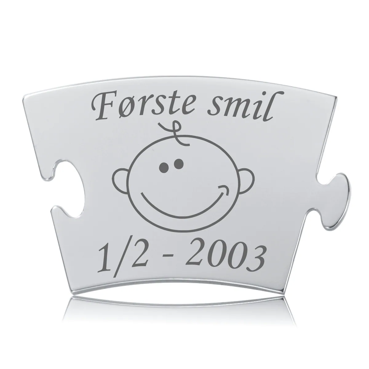 Memozz Classic brik med gravering af "Første smil" og et smilende babyansigt, i poleret rustfrit stål