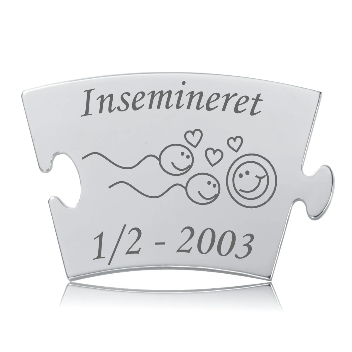 Rektangulær rustfri stål brik med graveret “Insemineret”, grafisk fremstilling af sædceller, ægcelle med smilende ansigter og små hjerter