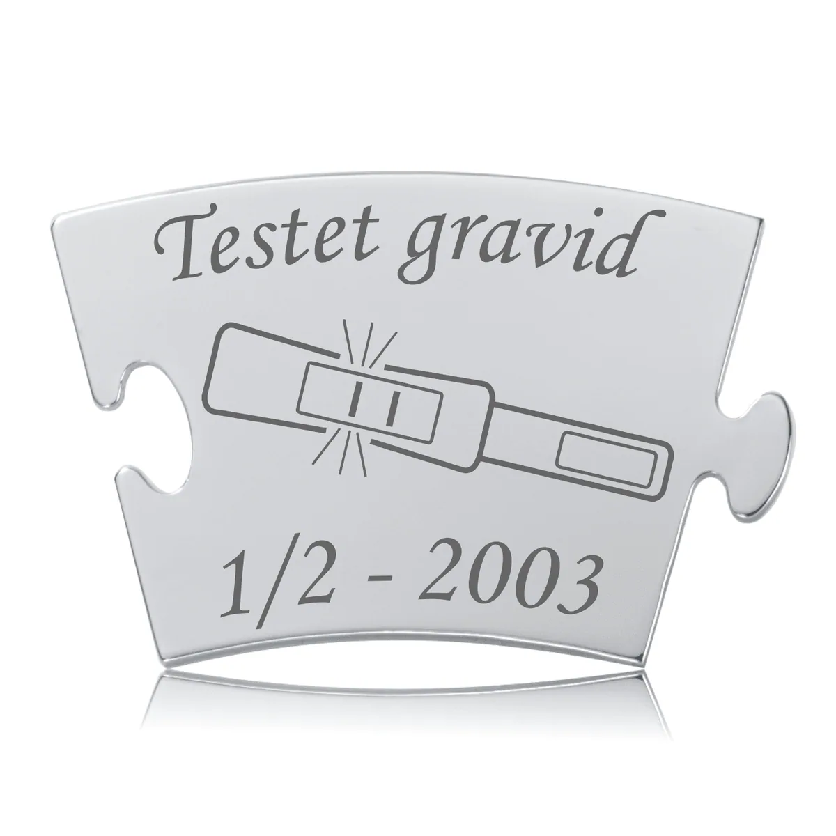 Blankpoleret Memozz Classic mindebrik med teksten "Testet gravid" og et ikon af en positiv graviditetstest graveret i mørkt stål.