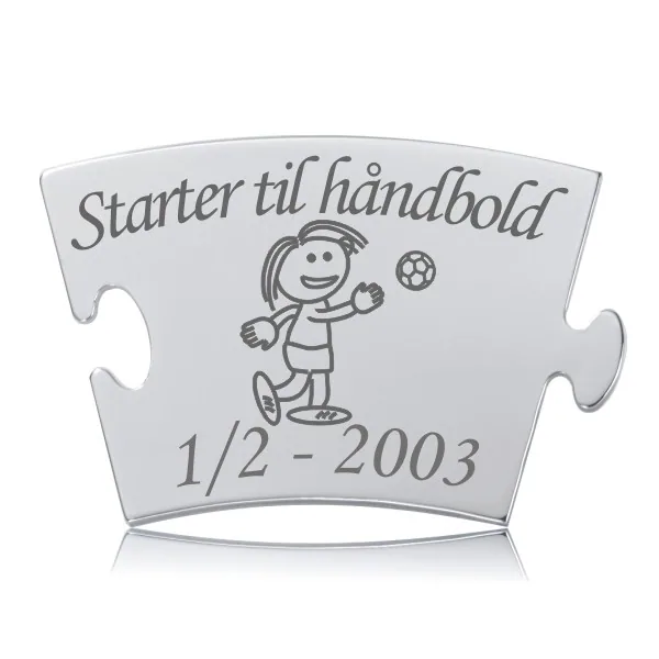 Memozz Classic brik "Starter til håndbold - pige" i skinnende, håndpoleret rustfrit stål med tydelig lasergravering af en glad pige med håndbold.
