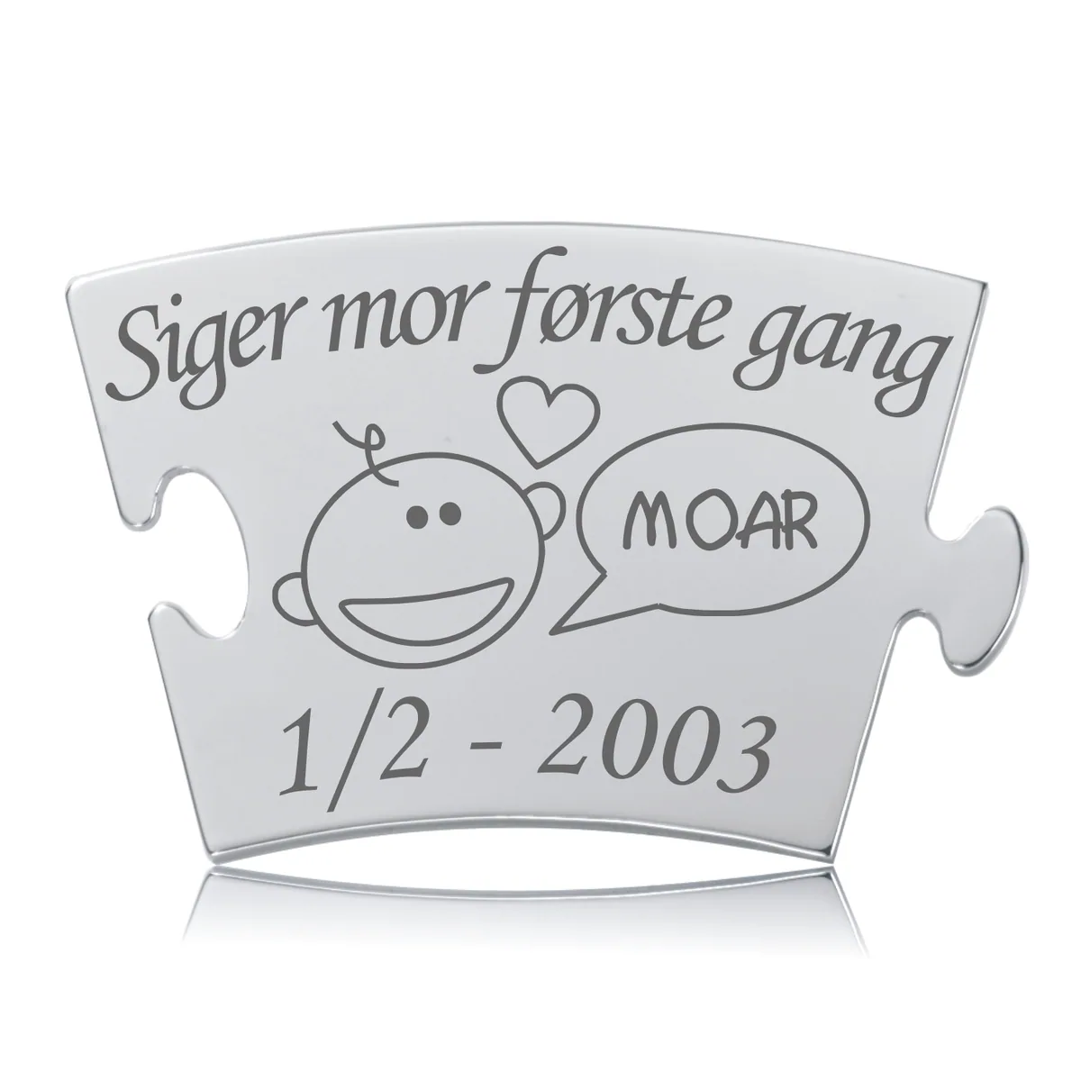 Memozz Classic brik "Siger mor første gang" i rustfri stål med gravering af smilende baby, hjerte og teksten "MOAR" samt en dato. Lys, skinnende overflade med mørk indgravering.