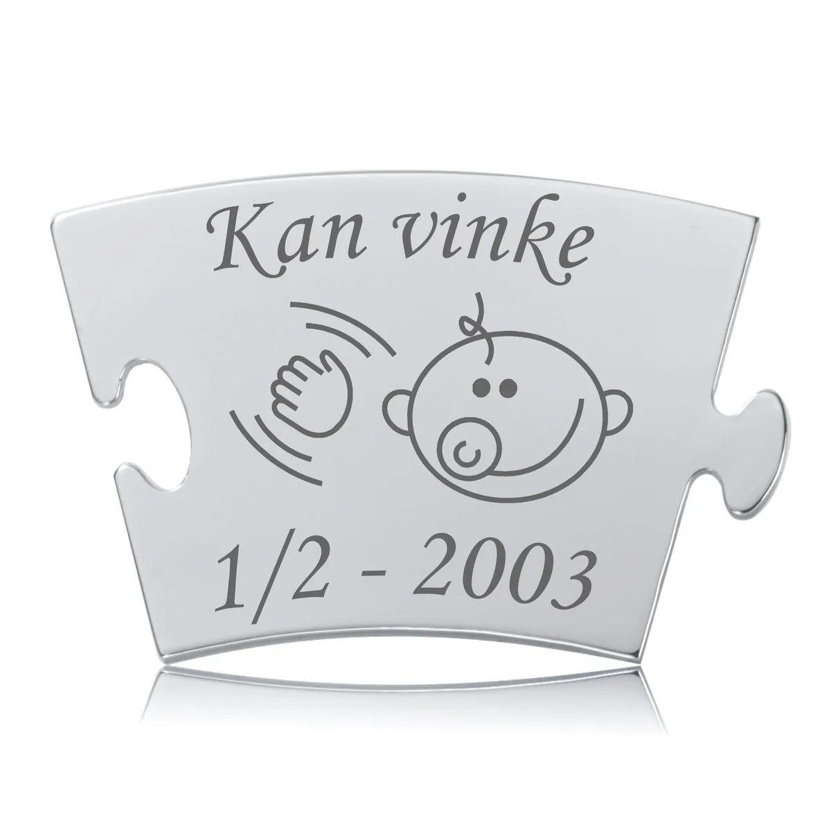Memozz Classic brik i rustfrit stål med gravering: "Kan vinke" og babyansigt. Glat, reflekterende overflade.
