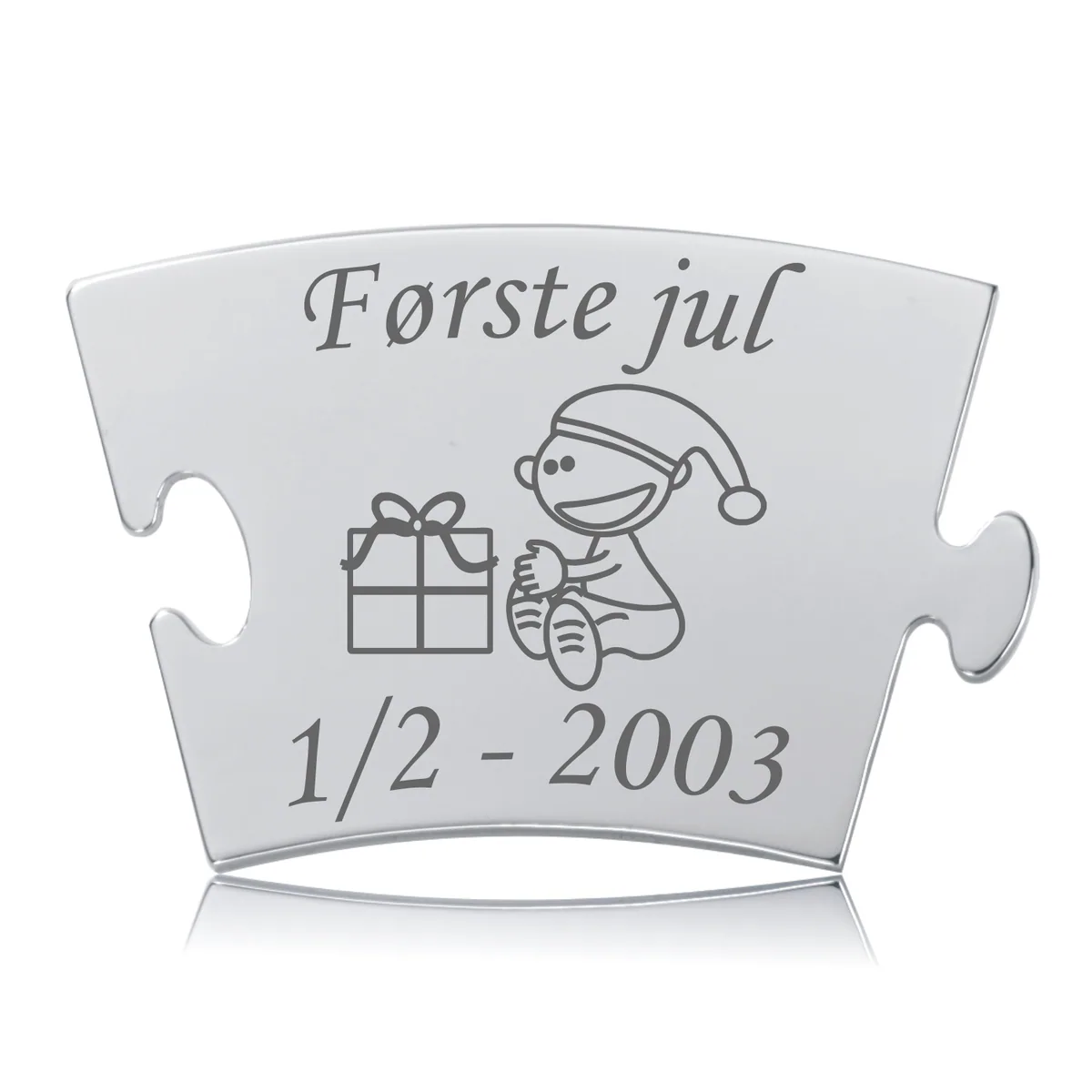 Memozz Classic mindebrik "Første jul - Model Gave" i rustfrit stål med gravering af smilende barn med nissehue, julegave og teksten "Første jul".