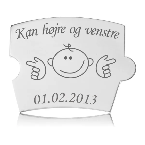 Memozz Spin brik i poleret rustfrit stål, der viser et smilende børneansigt, der peger til højre og venstre, med den graverede tekst "Kan højre og venstre" over og en dato under. Perfekt til milepæle.