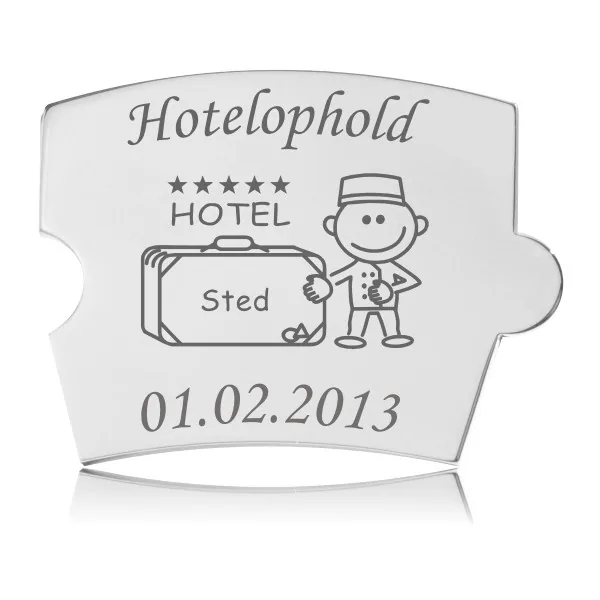 Memozz Spin Hotelophold mindebrik i håndpoleret rustfrit stål med gravering af hotel, kuffert og bellboy, som symboliserer en rejseoplevelse.