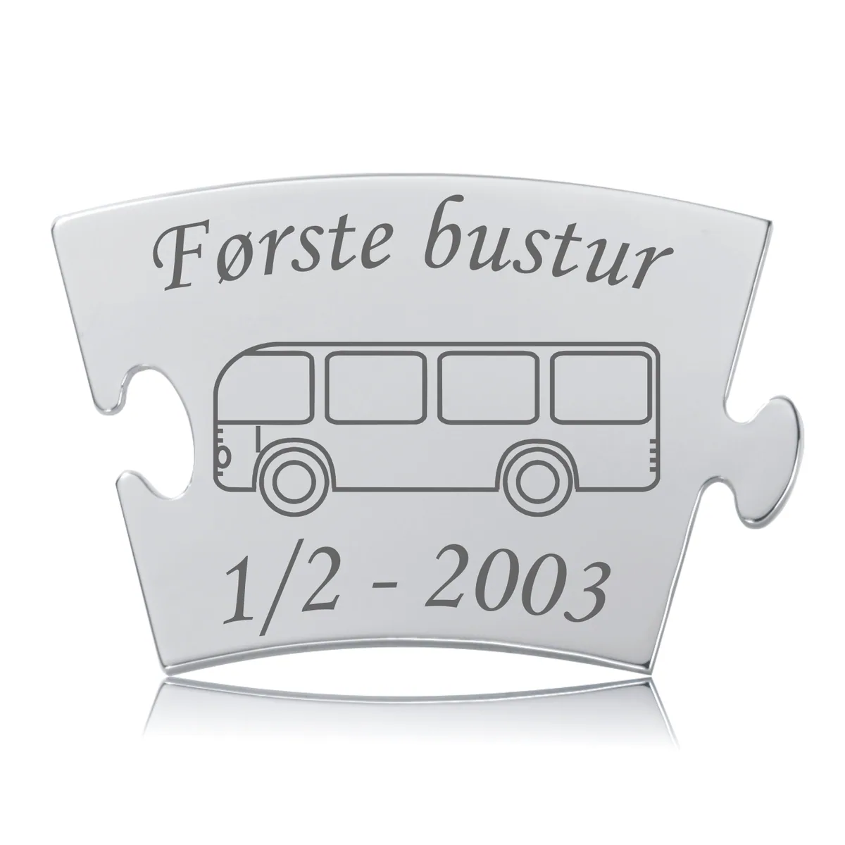 Memozz Classic brik "Første bustur" i skinnende rustfrit stål med mørk lasergravering af en bus og tekst.