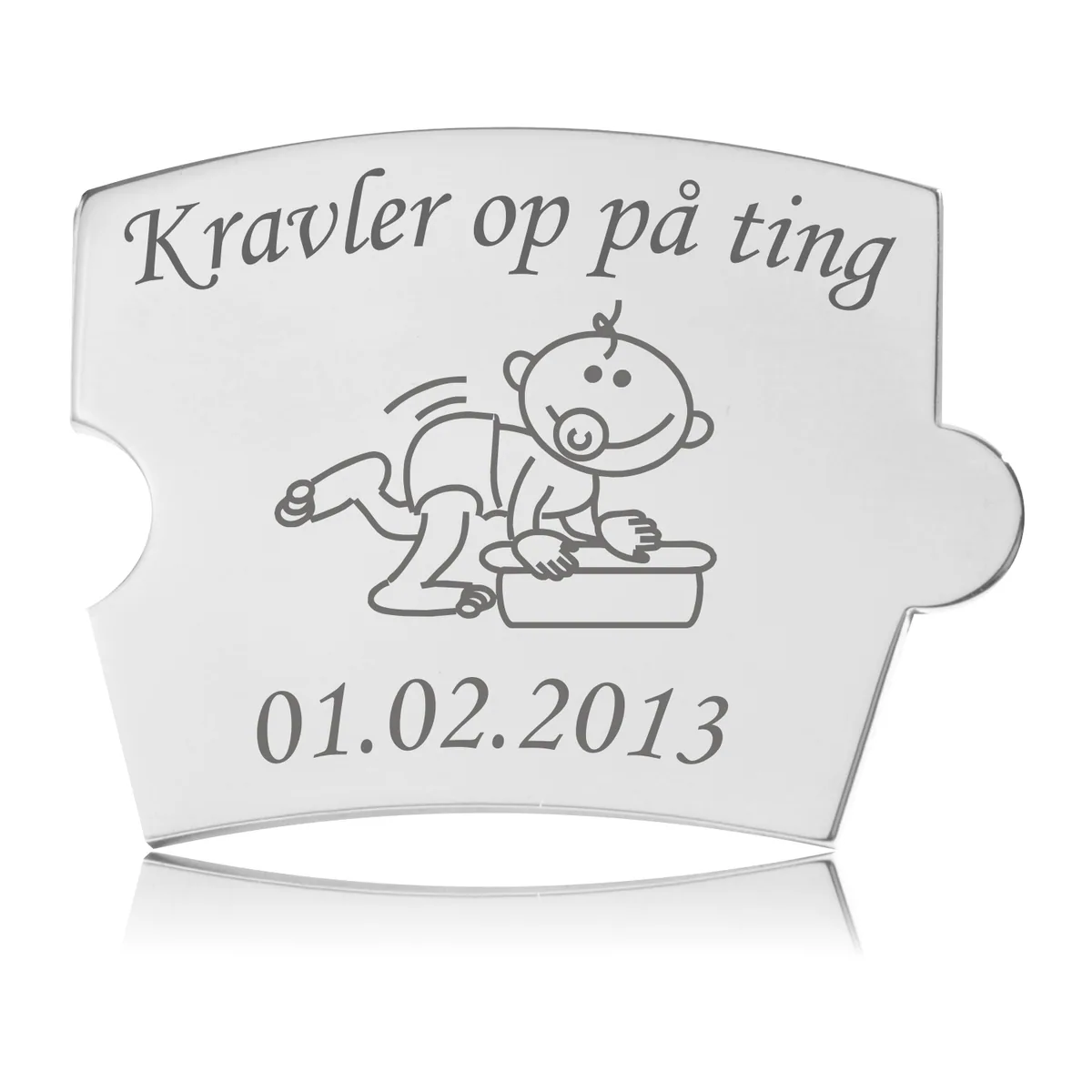 Memozz Spin brik i håndpoleret rustfrit stål med motiv af kravlende baby og "Kravler op på ting" i mørkegrå gravering