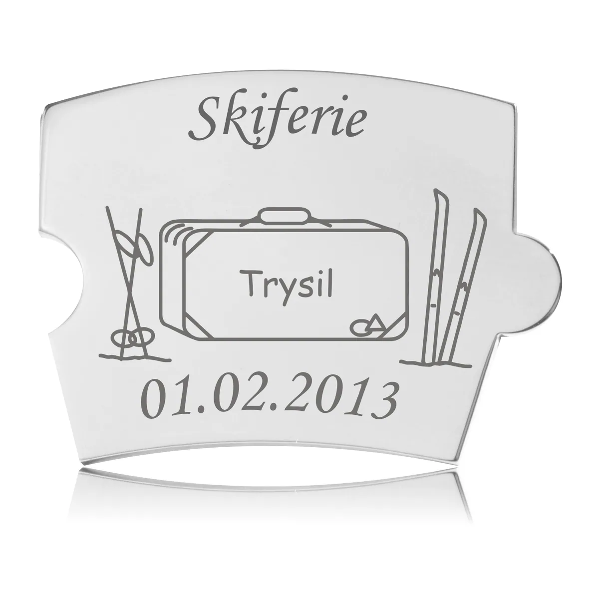 Memozz Spin brik i håndpoleret rustfrit stål med gravering af "Skiferie", kuffert med "Trysil" og ski, der symboliserer en mindeværdig skiferie.