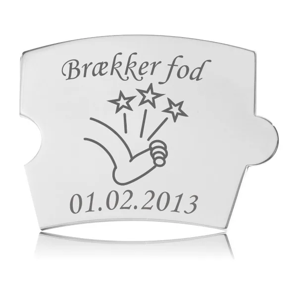 Memozz Spin mindebrik i håndpoleret rustfrit stål med gravering af en fod og ordene "Brækker fod"
