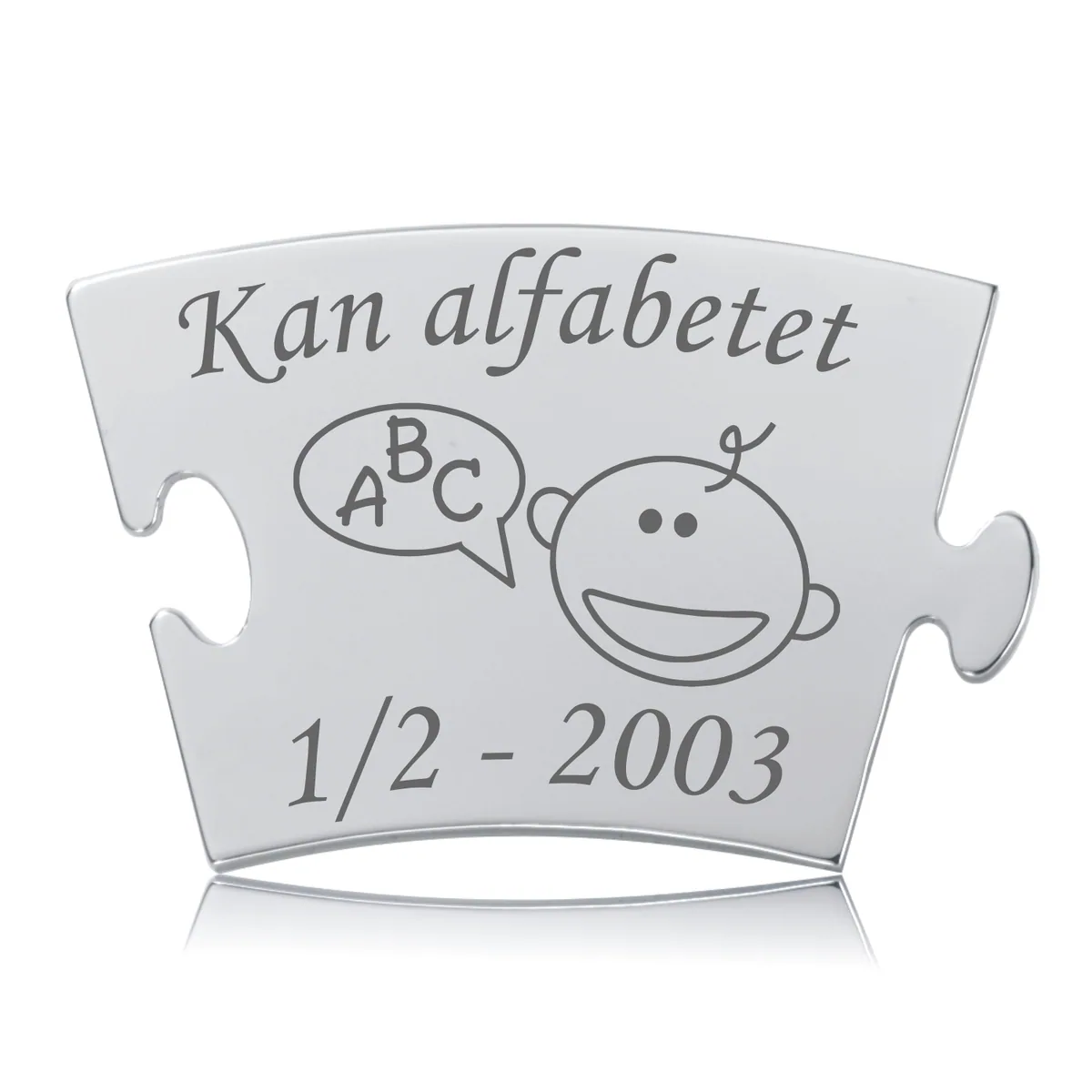 Memozz Classic brik "Kan alfabetet" i håndpoleret rustfrit stål med tydelig mørk lasergravering. Brikken viser teksten "Kan alfabetet" og et barnemotiv med ABC-bogstaver i en taleboble.
