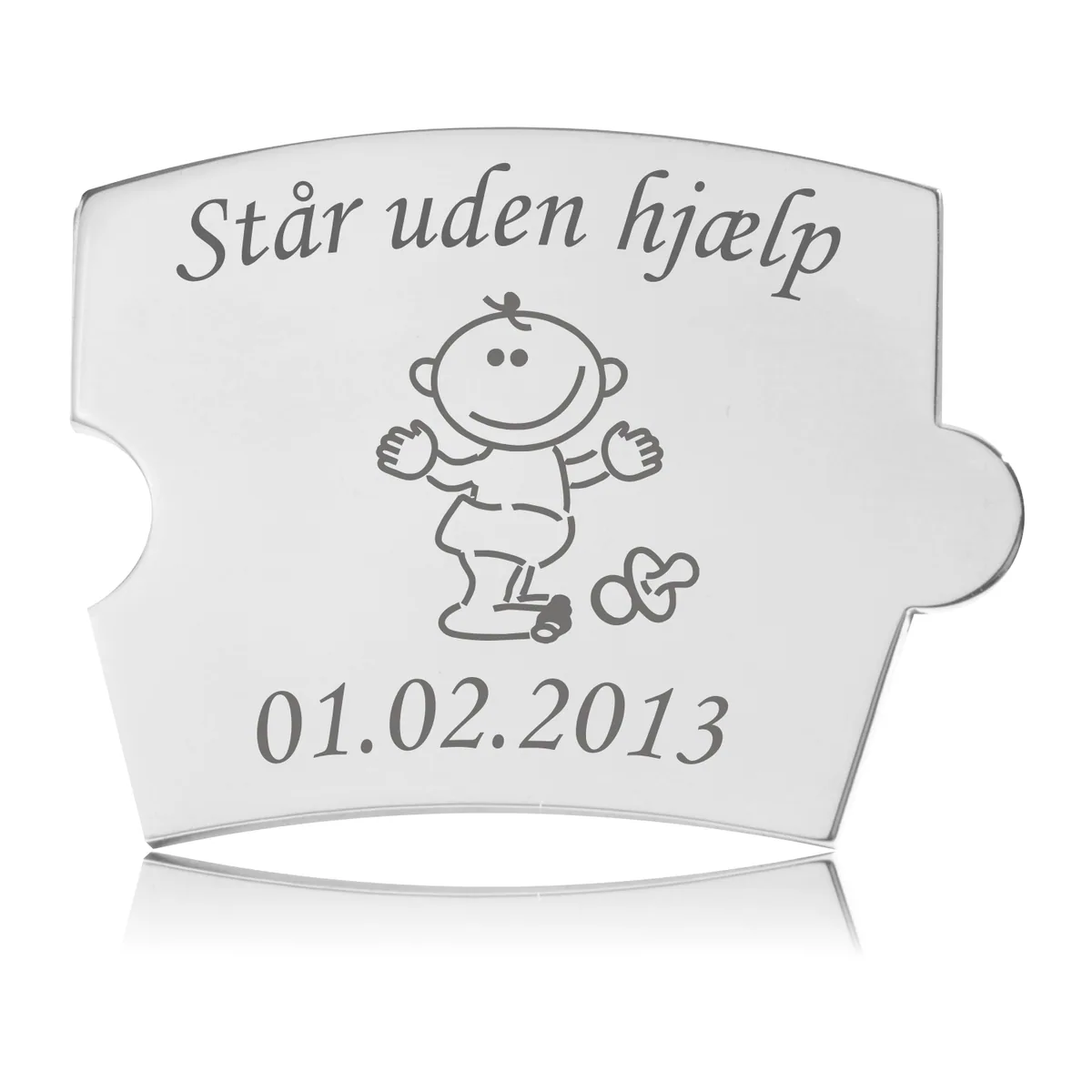 Memozz Spin brik i poleret stål med gravering 'Står uden hjælp' og en tegning af en baby. Brikken er til en mindetavle.