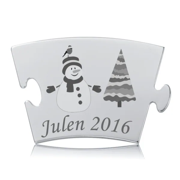 Årets Julebrik 2016 i rustfrit stål med graveret snemand og juletræ. Tekst: "Julen 2016".