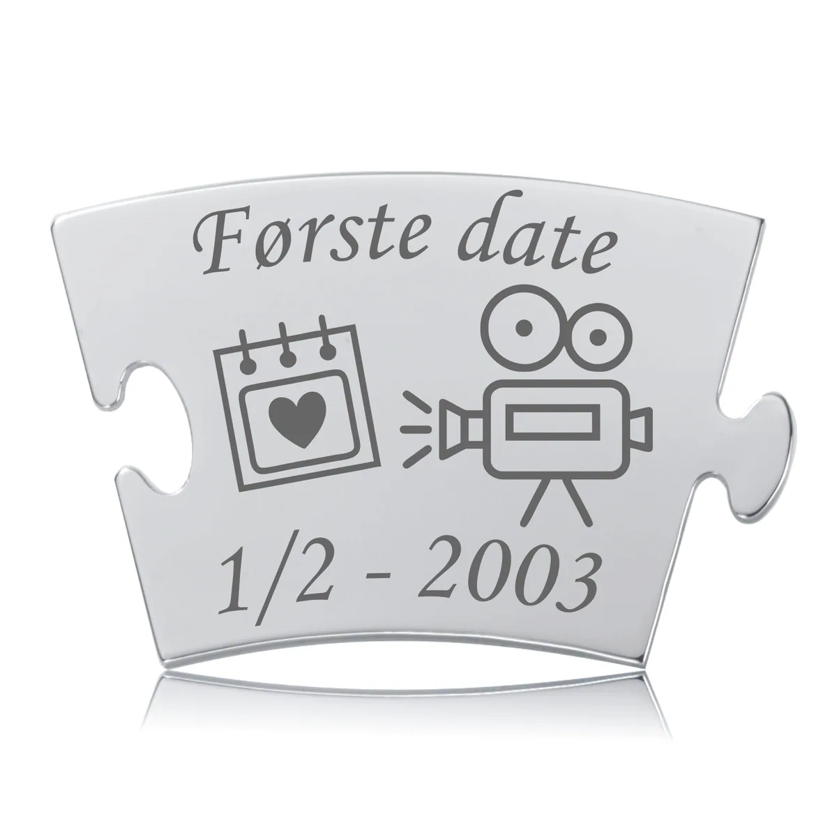 Første date Memozz Classic brik i håndpoleret rustfrit stål med gravering af kalender og filmkamera. Detaljeret og skinnende, med en datogravering under.