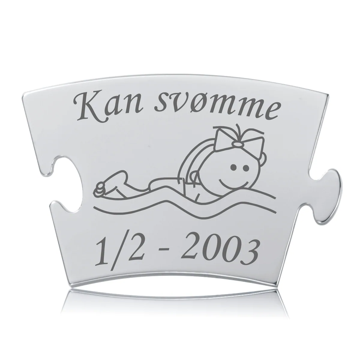 Memozz Classic brik "Kan svømme - Pige" med illustration af pige i vand og teksten "Kan svømme", håndpoleret rustfrit stål.