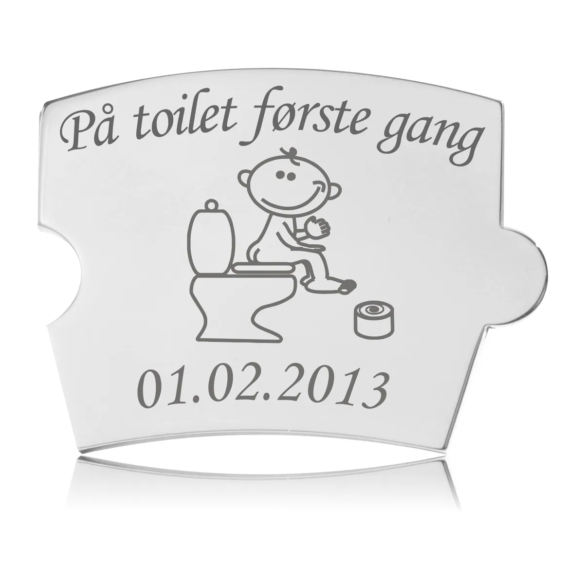 Memozz Spin brik i håndpoleret rustfrit stål med gravering af et barn på toilet og teksten "På toilet første gang".